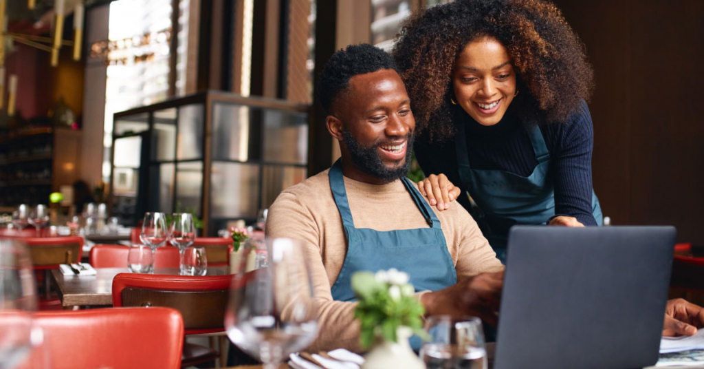 Small business owners using laptop in restaurant